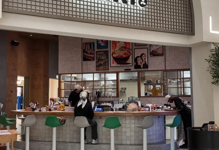 [OUT] Modern Japanese ramen restaurant interior with sleek wooden countertops, minimalist decor, and ambient lighting in Dubai, UAE. [/OUT]